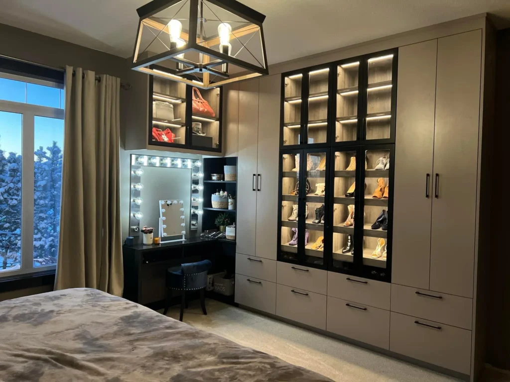 Dressing wall with a lit makeup station and glass fronted wardrobe doors