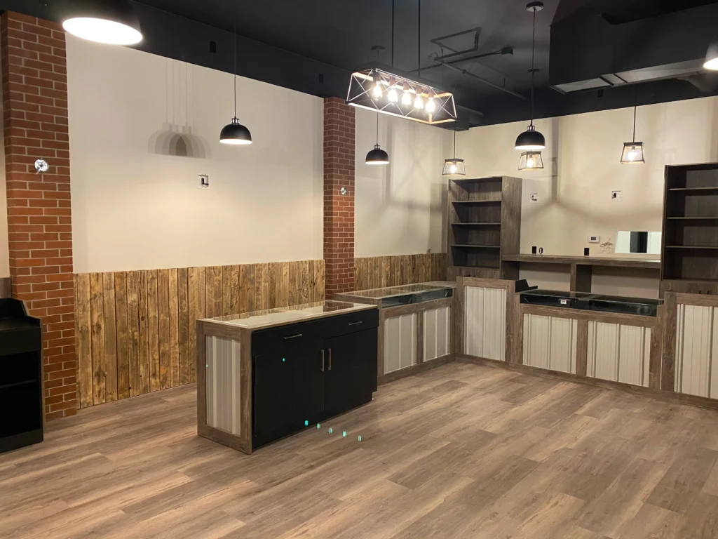 Commercial cabinetry along a brick wall with open shelving and a dark island
