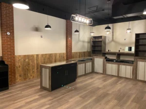 Commercial cabinetry along a brick wall with open shelving and a dark island
