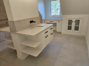 Painted island with open end shelving in a kitchen before the appliances went in