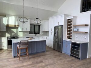 White shaker kitchen with a navy island, open shelving and a built-in wine rack