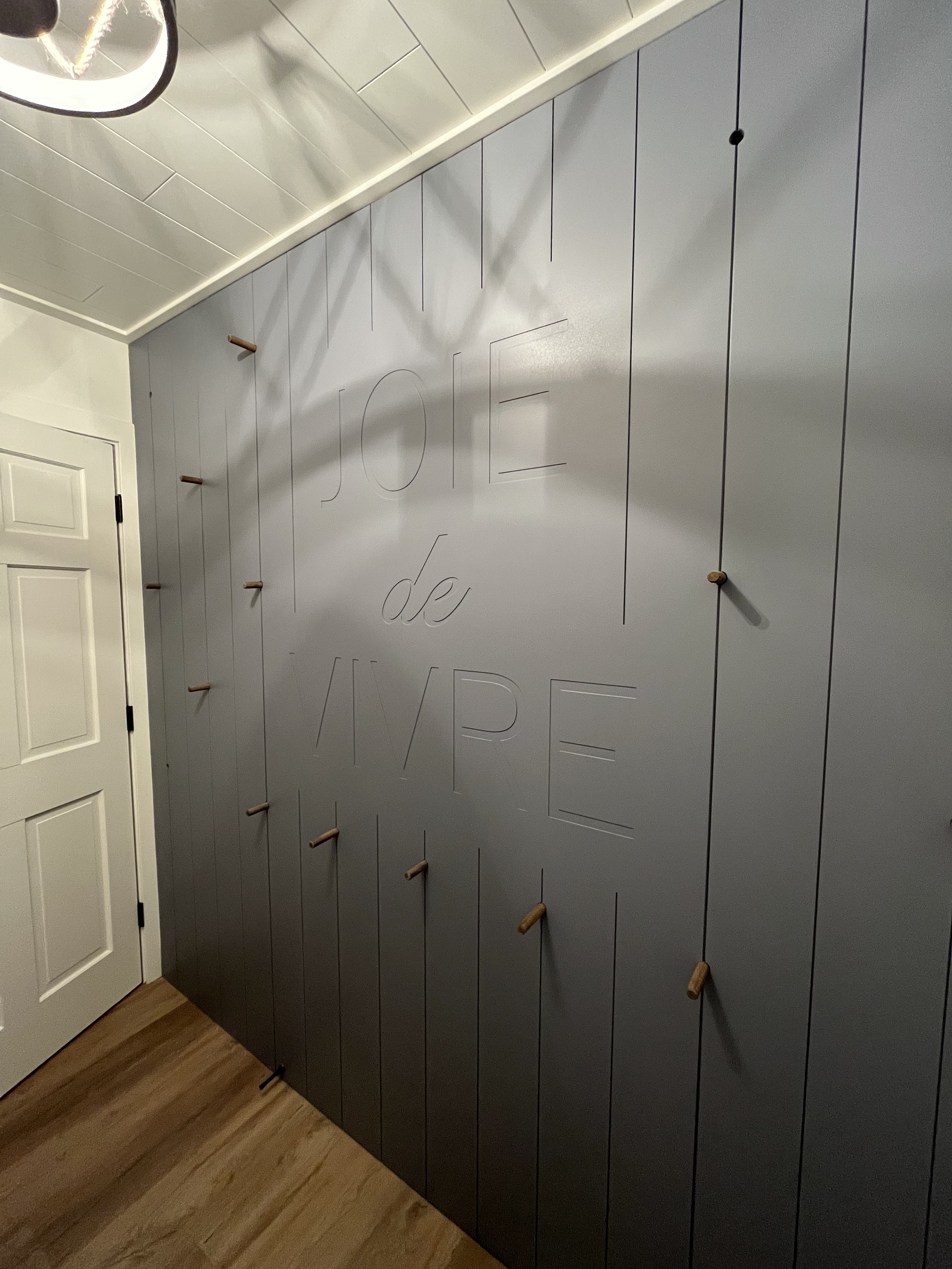 Routed lettering carved into a painted mudroom panel wall